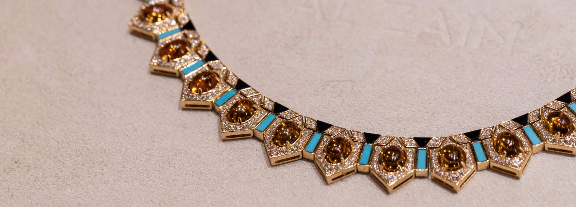 Rose gold watch with diamond-set bezel and black strap on display.