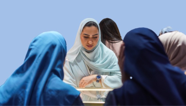 Women in hijabs browse and shop for jewelry in a vibrant store filled with various sparkling pieces.