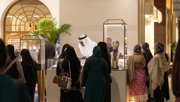 A diverse group of individuals standing together in a well-lit room, engaged in conversation and interaction.