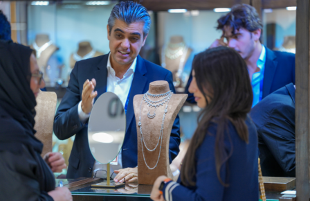 Jewellery salesperson presenting a necklace display to a customer in a jewellery exhibiton.