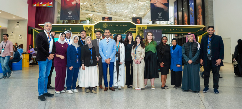 Group of Informa colleagues posing for a photo in front of the Jewellery Arabia arch